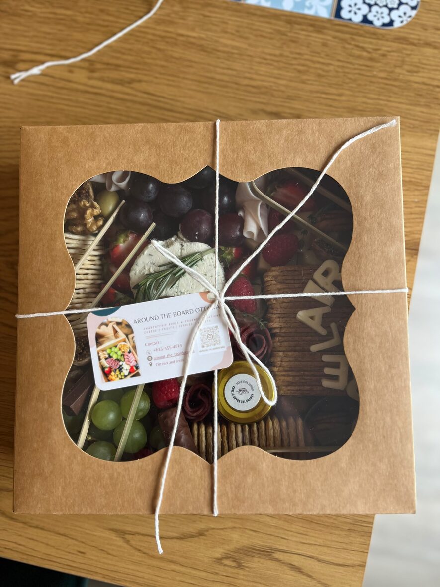Large grazing box tied with twine and a branded Around the Board Ottawa gift card