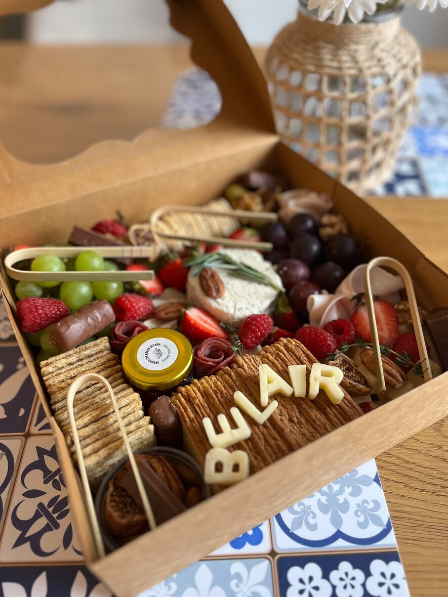 Gift-wrapped large grazing box with the lid closed and branded card, ready for delivery