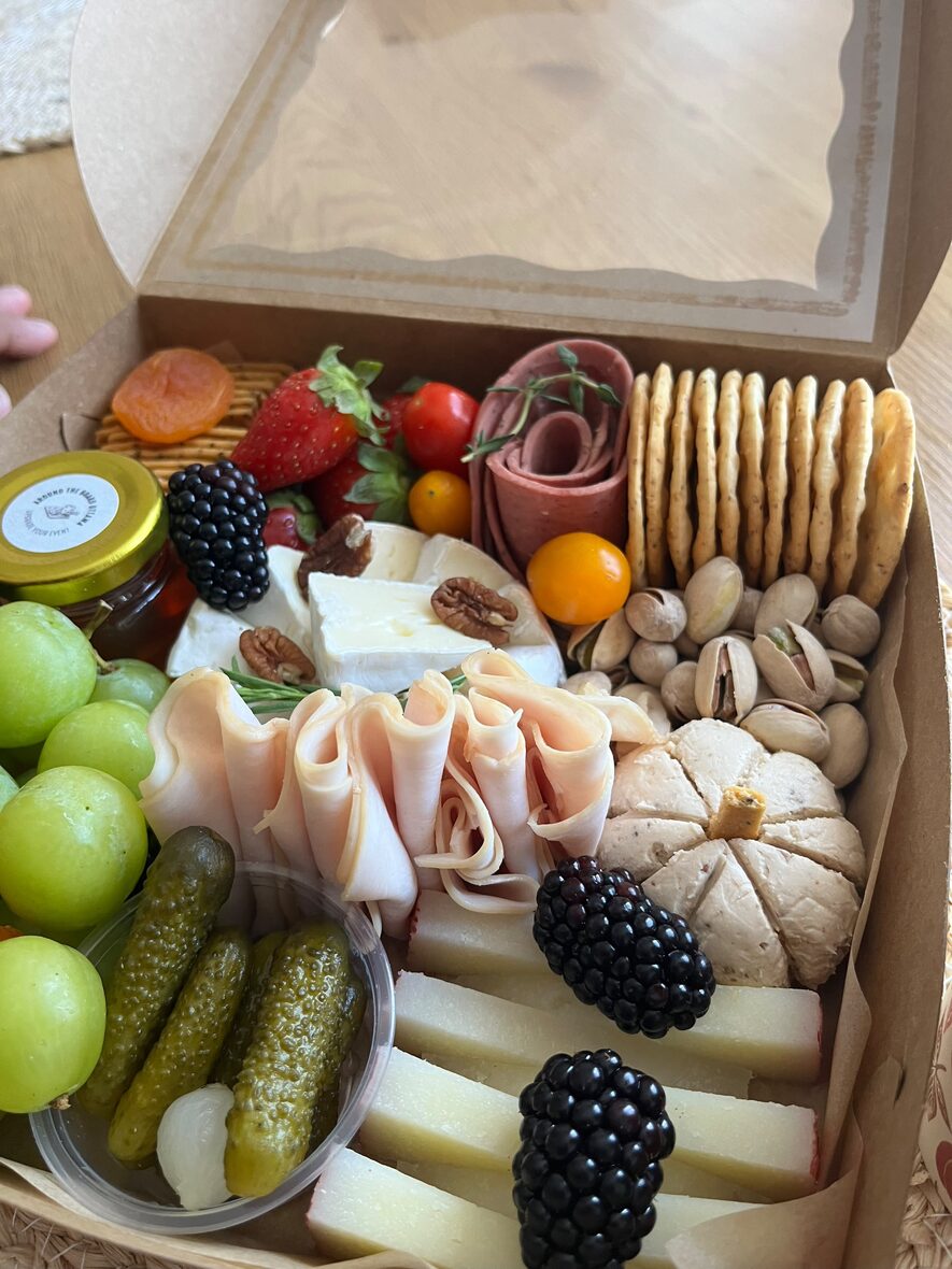 Medium grazing box detail with brie wheel, rosemary, blackberries and honey jar