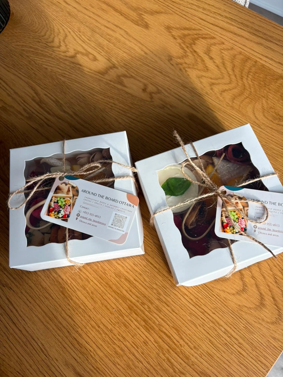 Gift-wrapped mini grazing boxes with twine and a branded Around the Board Ottawa card